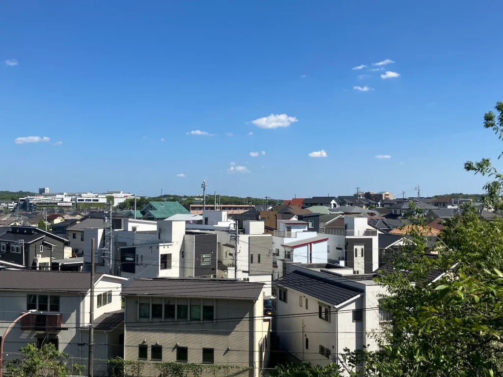 御旗山中腹からの景色（写真中央に古戦場公園の木々、写真左に白いイオンモール長久手が見える）
